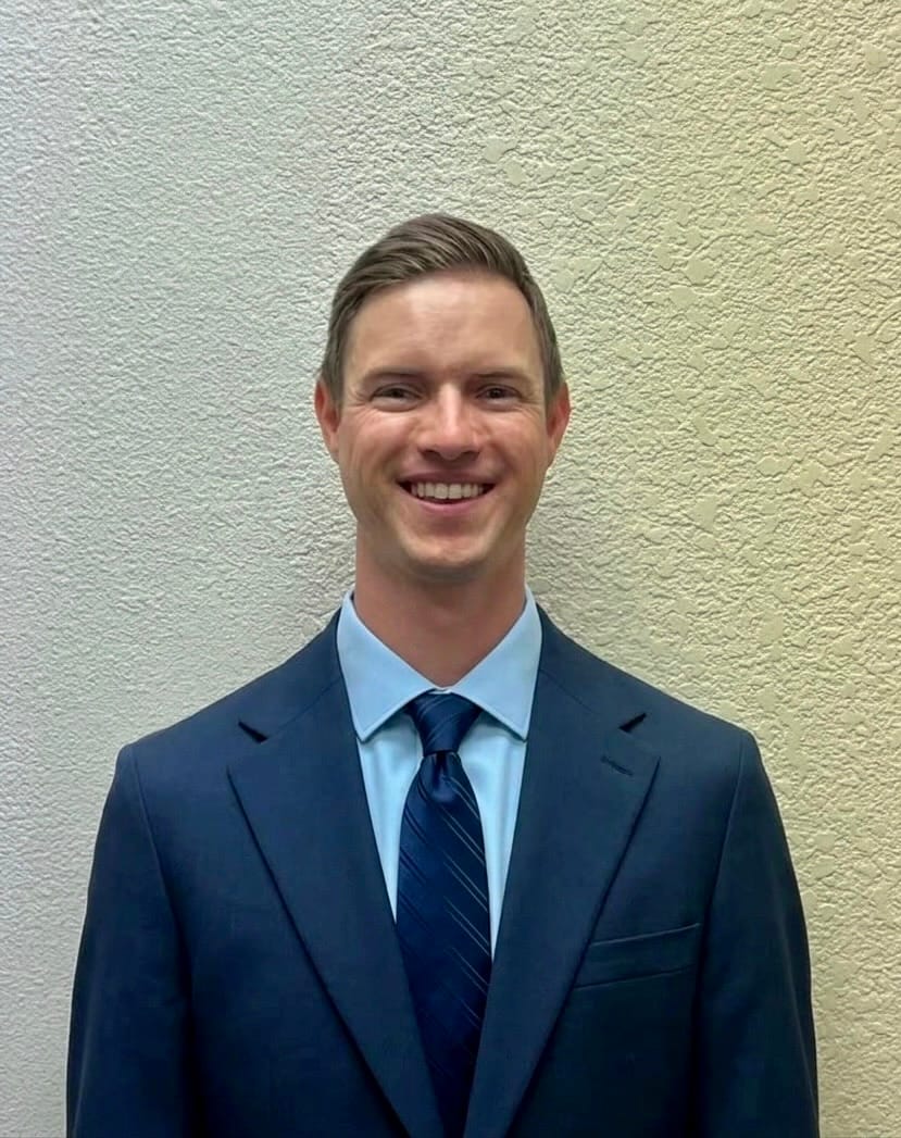 Dr. Evan Hill, smiling, in a navy suit and tie
